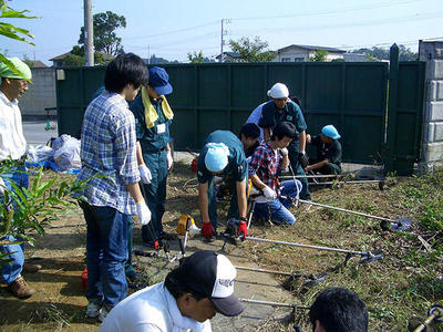 初参加の新入社員は草刈機の使い方を習得中。